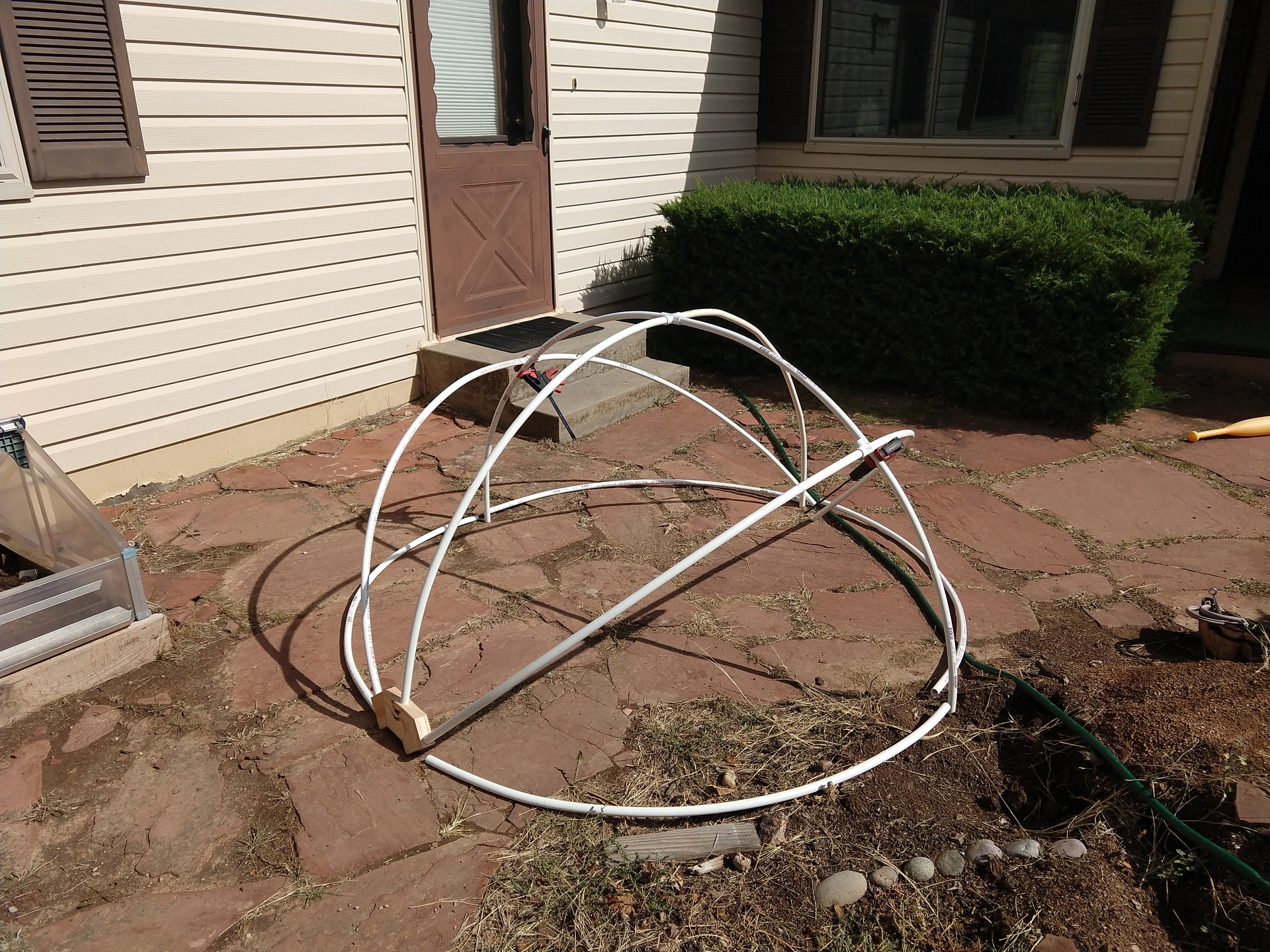 The initial frame being built out of curved PVC pipe